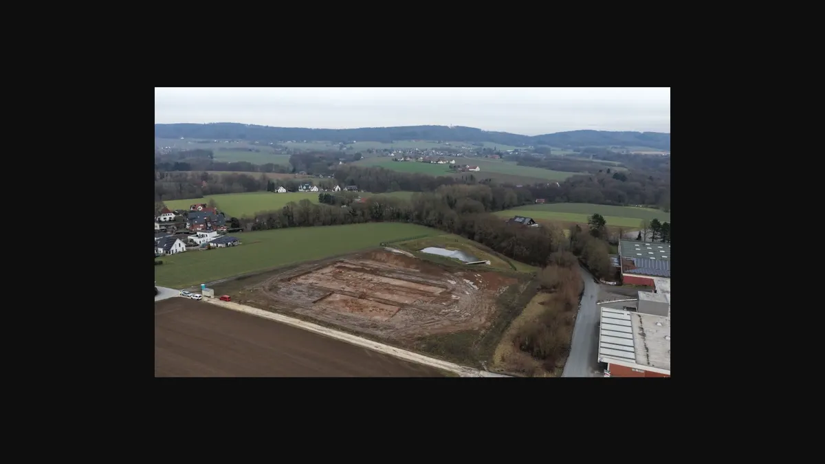 Excavation manager Hisham Nabo (left) and excavation worker Ristam Abdo (right) stand in an excavated settlement pit and examine some of the shards found there.