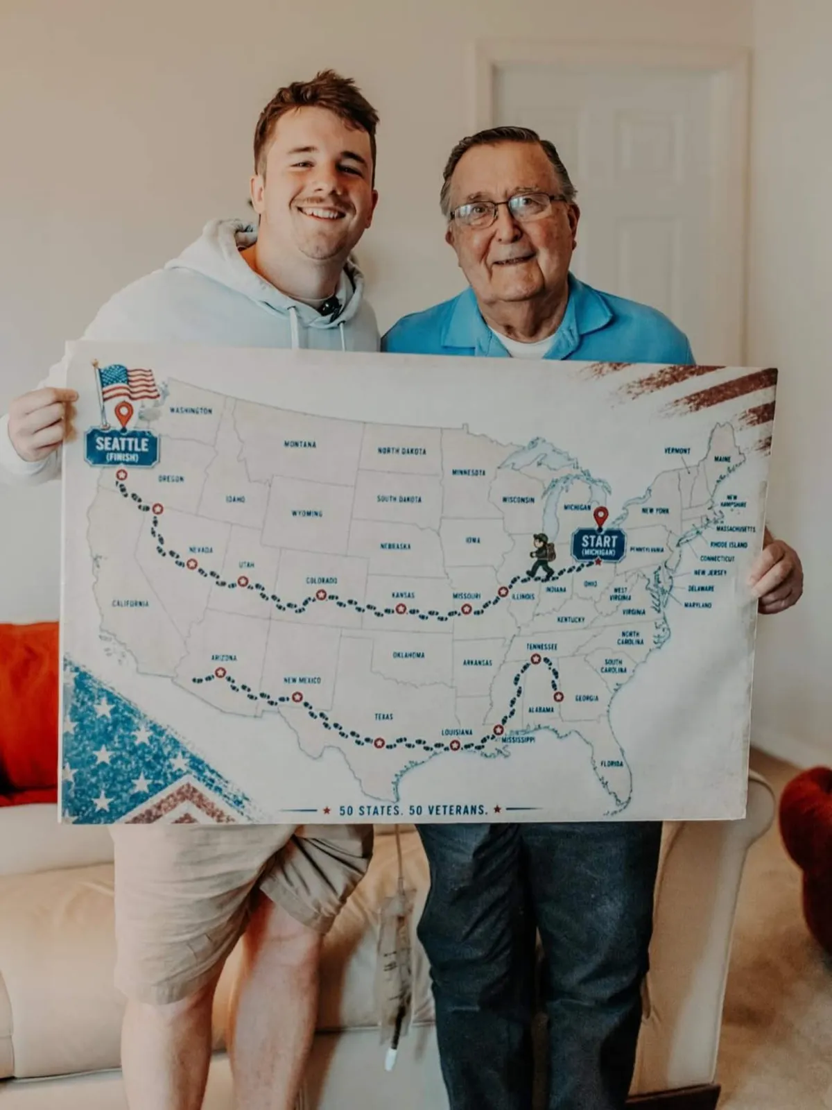 A young man, Sam Weidenhofer, and an older man, veteran Ed Bambas, smile together while holding up a map of the United States