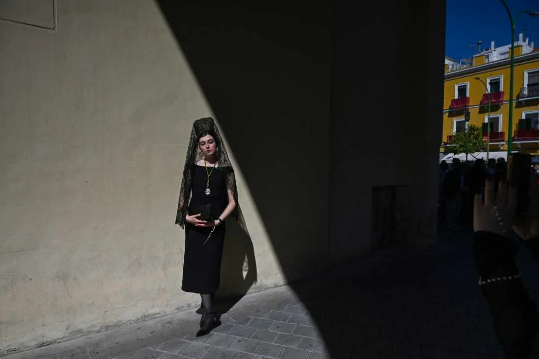 A woman wearing a traditional shawl known as a "mantilla" stands outside the Basilica de la Macarena church during Holy Week in Seville on April 2, 2026.