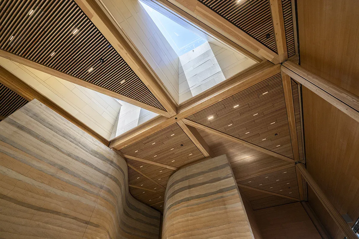 Angular skylights illuminate the rammed earth walls and pathways inside the library