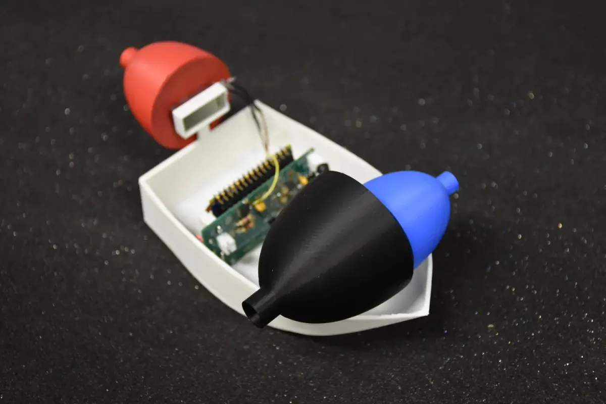 A miniature boat equipped with a bell-shaped acoustic cavity.