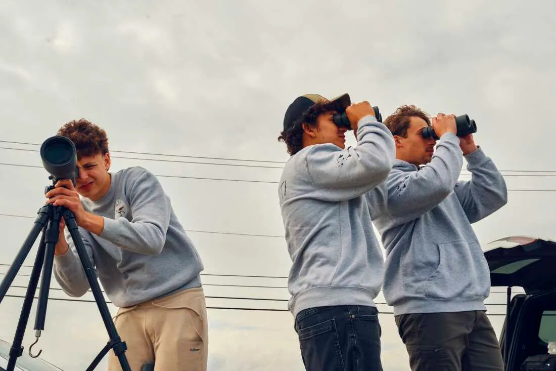 Train (left), Pacetti and Trojan look through a scope and binoculars at Malibu Beach Wildlife Management Area.