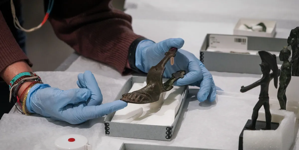 hands hold a bronze furniture foot