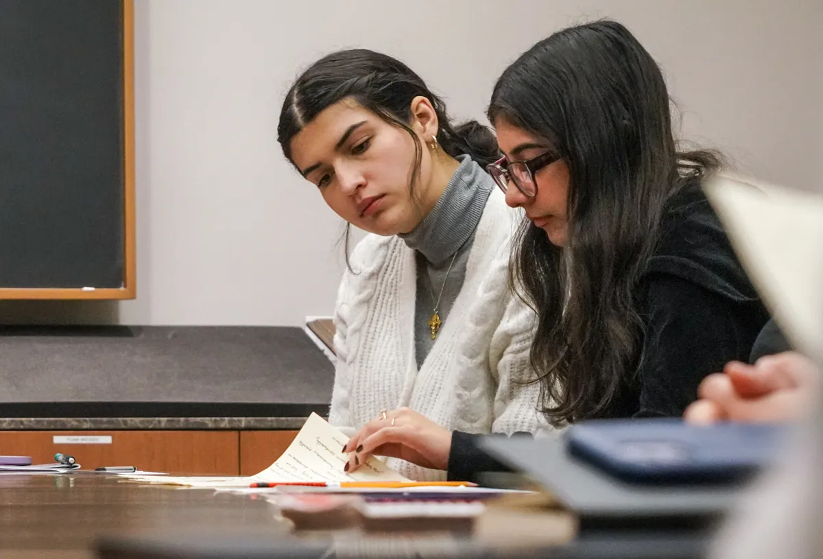two students leaf through a letter