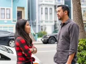 Two people chatting in the street, one with arms crossed