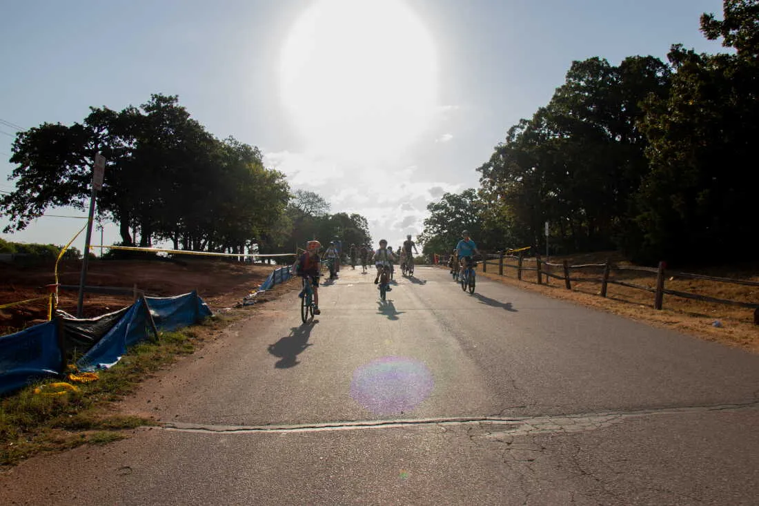 Will Rogers Elementary students cruise down a hill on their route to school after a routine brake check. Parents, students and a car monitor ride about a mile from the park to the school as part of what’s called a bike bus.