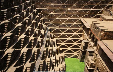 A deep and very large well with thousands of symmetrical steps that create a geometric zigzag pattern
