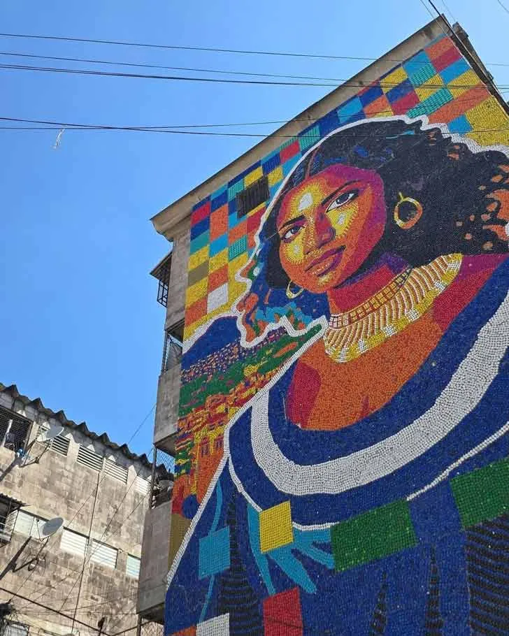 A colorful mural depicts a Salvadoran woman out of 100,000 bottle caps