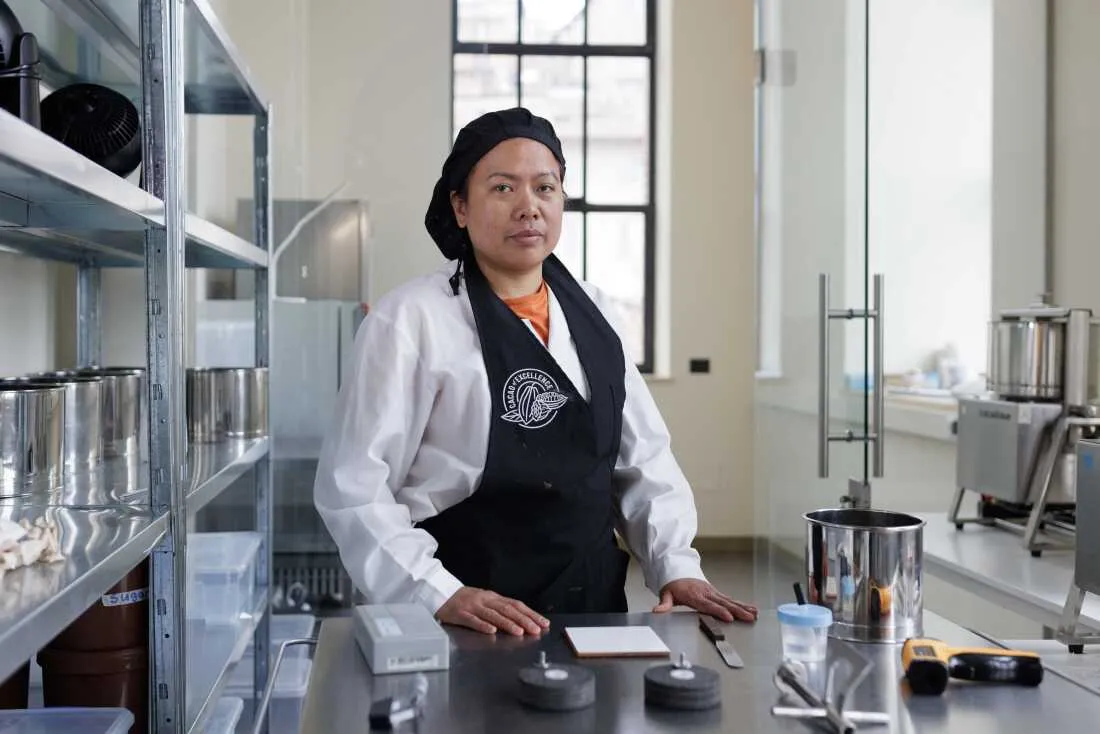 Lab Assistant Julia Butac poses for a portrait at the Cacao of Excellence laboratory in Perugia. As part of the technical team, she assists in the physical and sensory analysis of cocoa samples from around the world, supporting the organization's mission to establish global quality standards and reward the flavor diversity of superior cocoa origins.