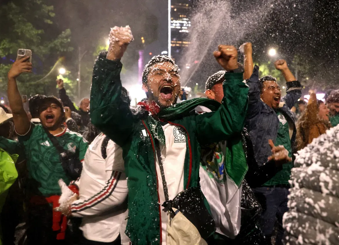 Fans covered in snow from a machine celebrate their first goal scored by Julian Quinones, in Mexico City.