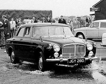 Queen Elizabeth II driving a Rover across muddy turf in Windsor Great Park in 1963.