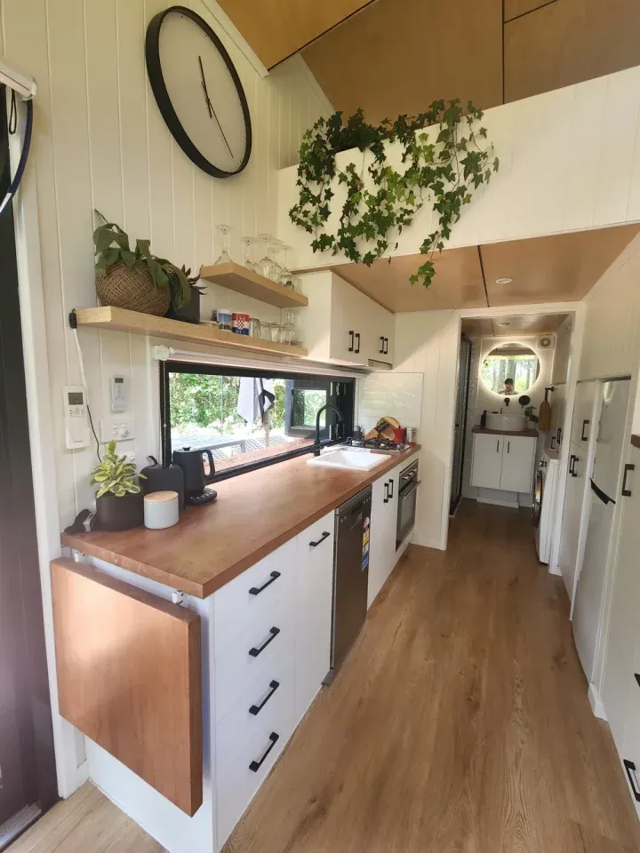 The Currumbin's kitchen occupies the center of the home and includes an oven and propane-powered cooktop, a sink, a fridge/freezer, and a dishwasher