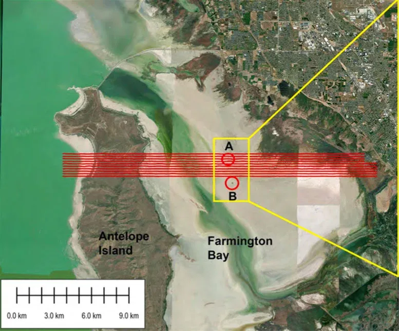 Map of the airborne electromagnetic survey area overlaid on the ESRI World Imagery basemap. Flight- line locations are shown in red and cross Antelope Island and Farmington Bay. The circles indicate locations of phragmites mounds.