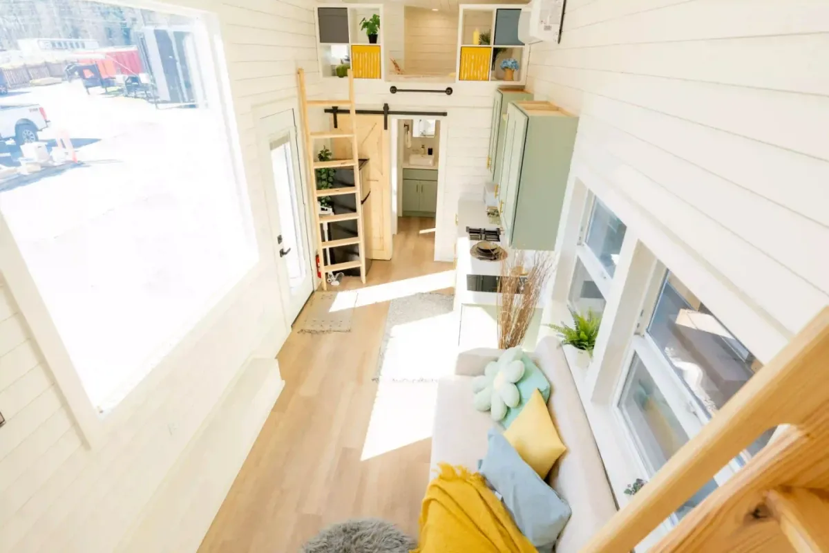 The living room in the Avalon 32' includes a sofa with integrated storage and a wall-mounted TV