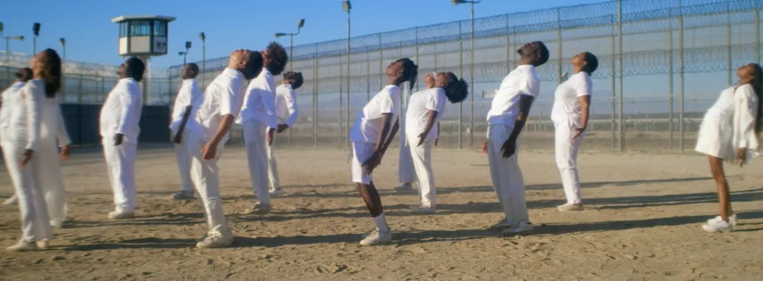 Actors gaze up to the sky during JJ'88's "ROOT" in the hip-hop artist and former inmate's documentary-visual album Songs from the Hole. Before the song starts, protagonist and producer James "JJ'88" Jacobs describes meditating on his and others' redemption while incarcerated and in solitary confinement.