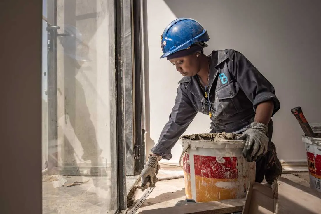 Tiler Margaret Klamiatha, a graduate of the Buildher Academy, photographed at work on a construction site at the Tatu City development on the edge of Nairobi, kenya.