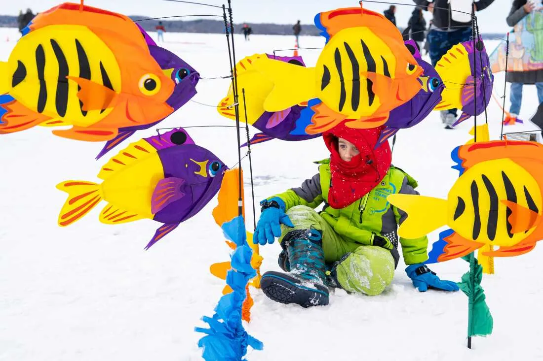 A child plays in a sea of fish kites at the Frozen Assets Festival on Lake Mendota.