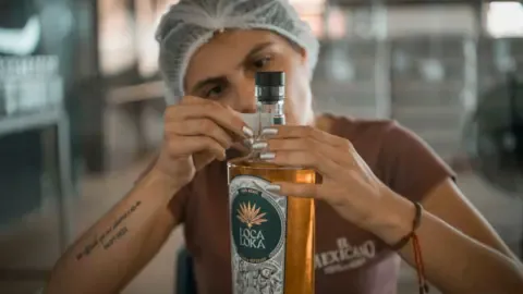 A worker puts a label on a bottle of Loca Loka tequila
