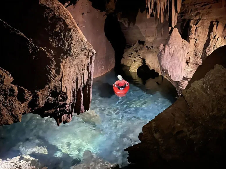 Explorer Kayaking in Flooded Cave Chamber