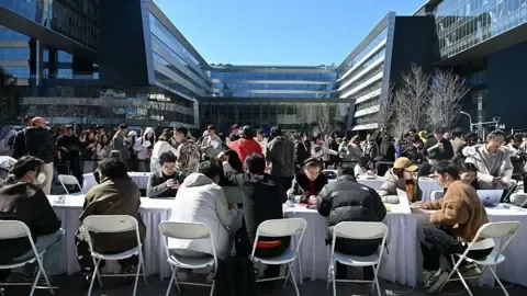 Engineers (front) install and set OpenClaw, an open-source AI assistant at the Baidu headquarter in Beijing on March 11, 2026