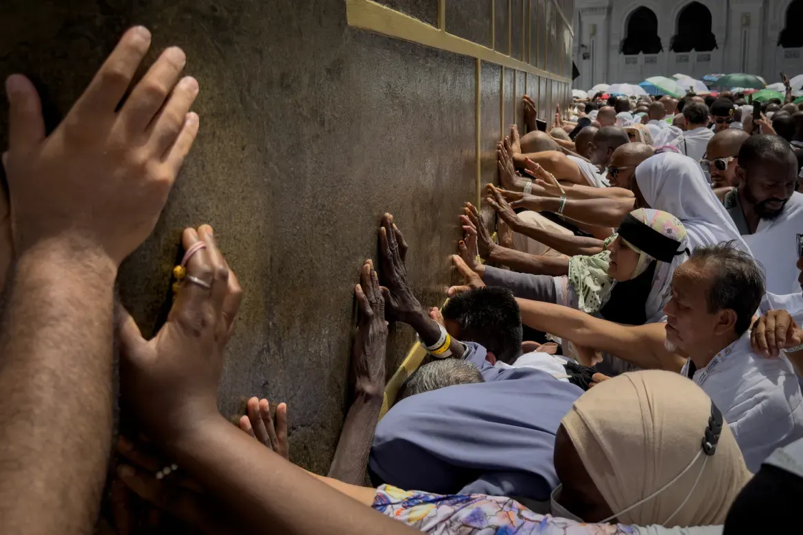 Muslim pilgrims touch the walls of the Kaaba, the cubic building at the Grand Mosque.