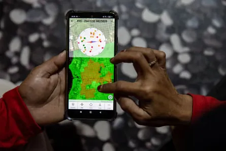 A member of the Power of Mama team shows a map and coordinates of detected fires on a smartphone in Sungai Putri village, Ketapang Regency, West Kalimantan province, Indonesia, 20 August, 2026.