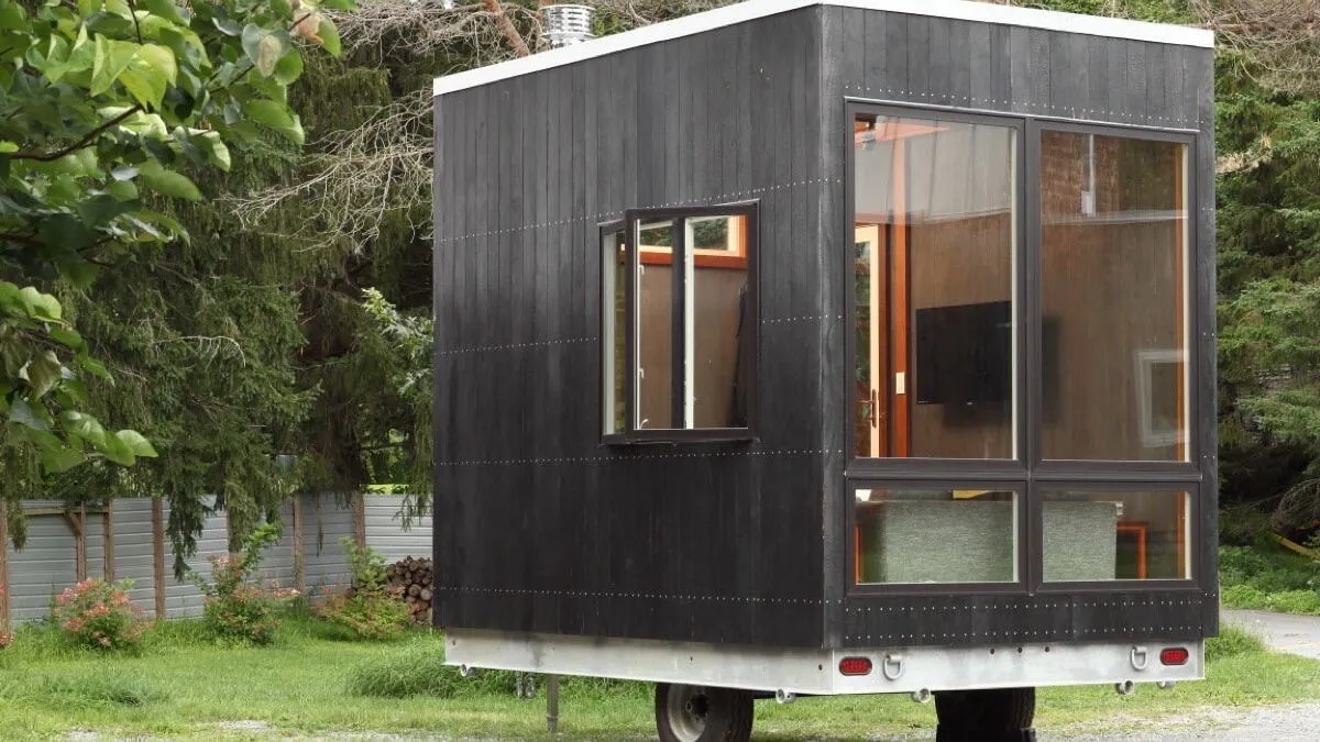 Space-saving cuboid tiny house stows a bed beneath its floor